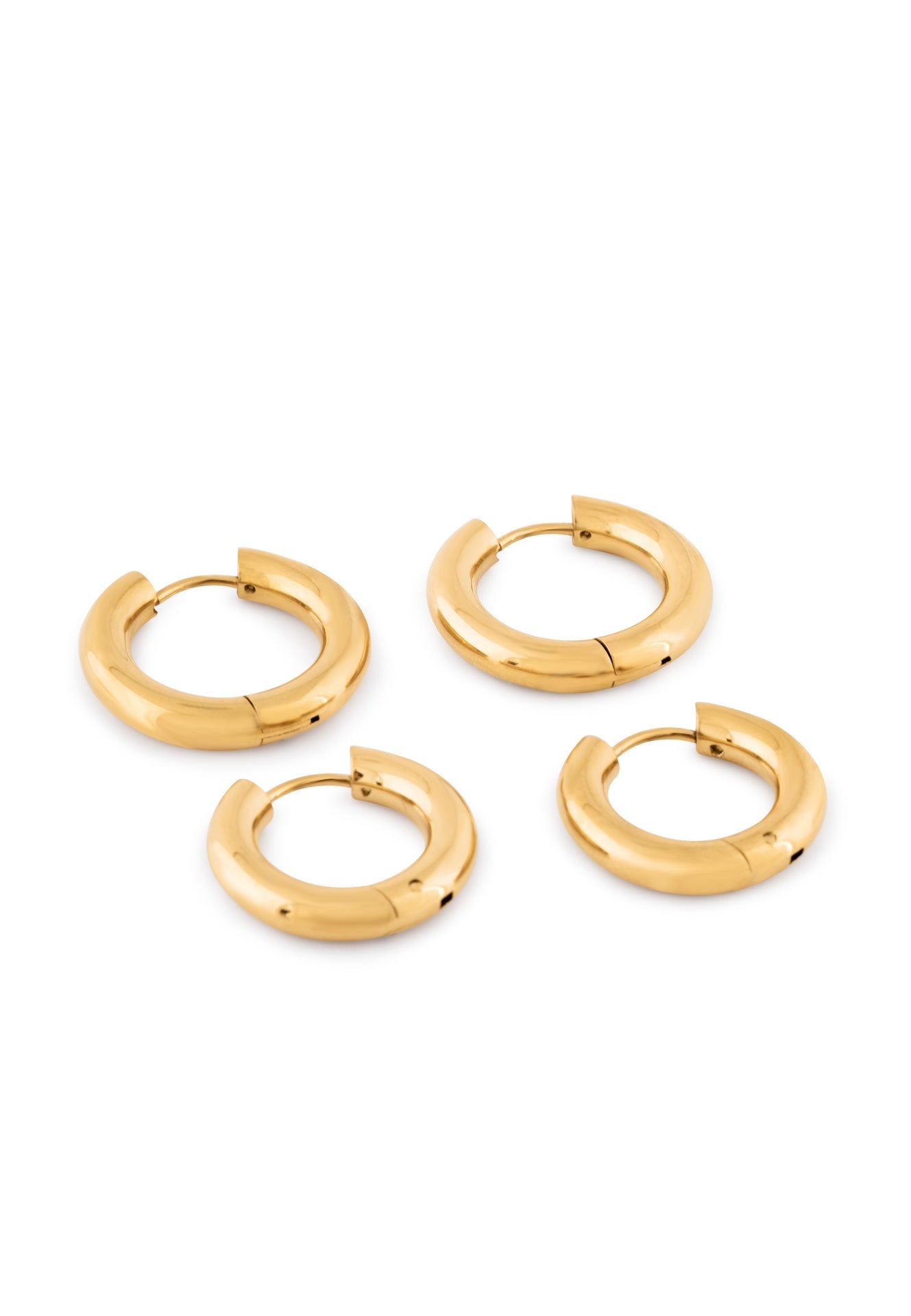 Set of gold hoop earrings on a white background