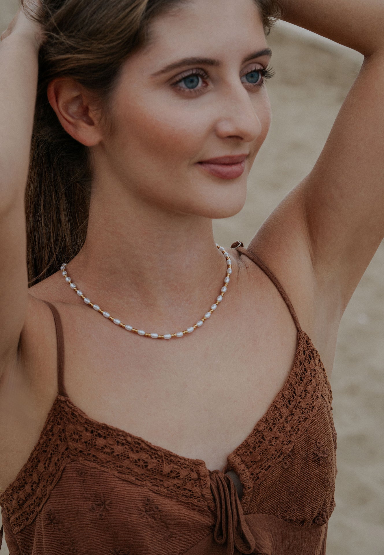 Woman wearing a pearl necklace on a beach