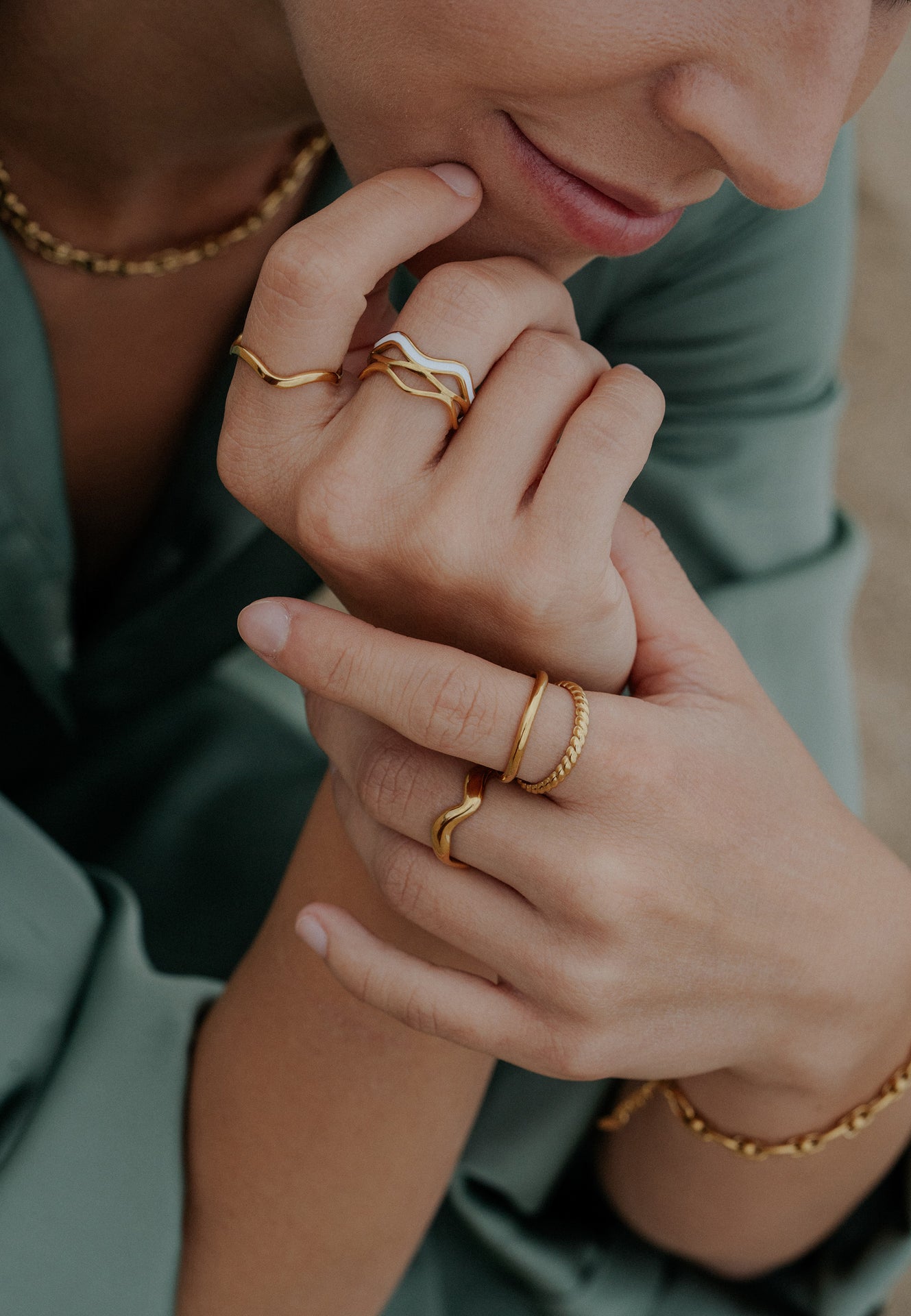 Close-up of hands wearing gold rings and bracelets
