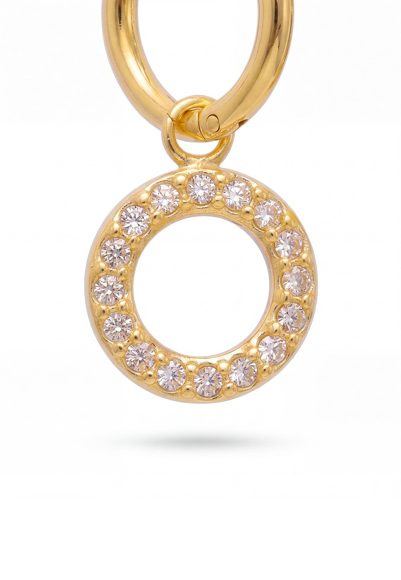 Gold earring with circular design and embedded crystals on a white background