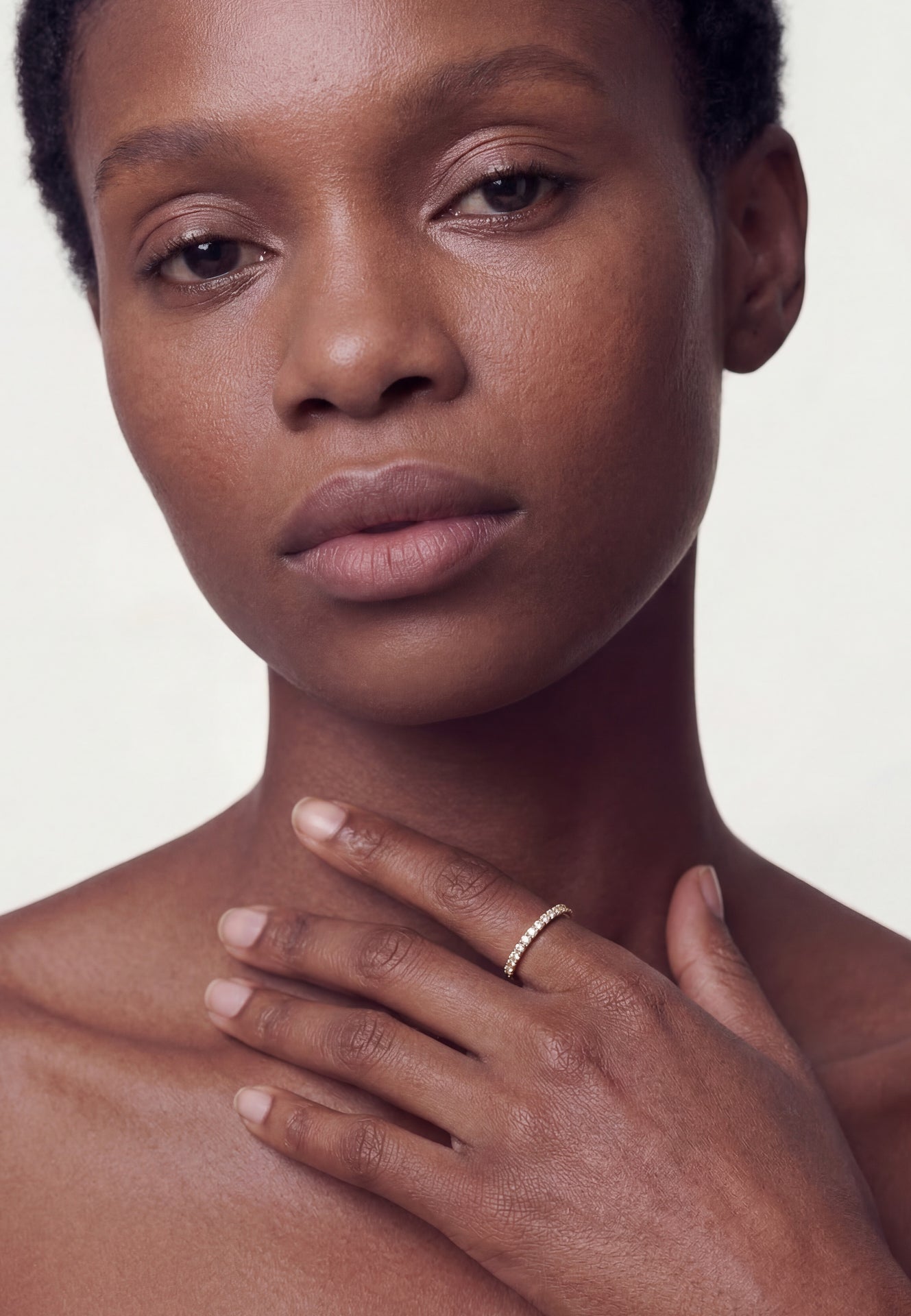 Close-up of a person with a neutral expression on a plain background