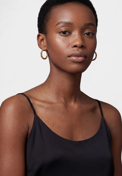 Woman wearing a black top against a plain background