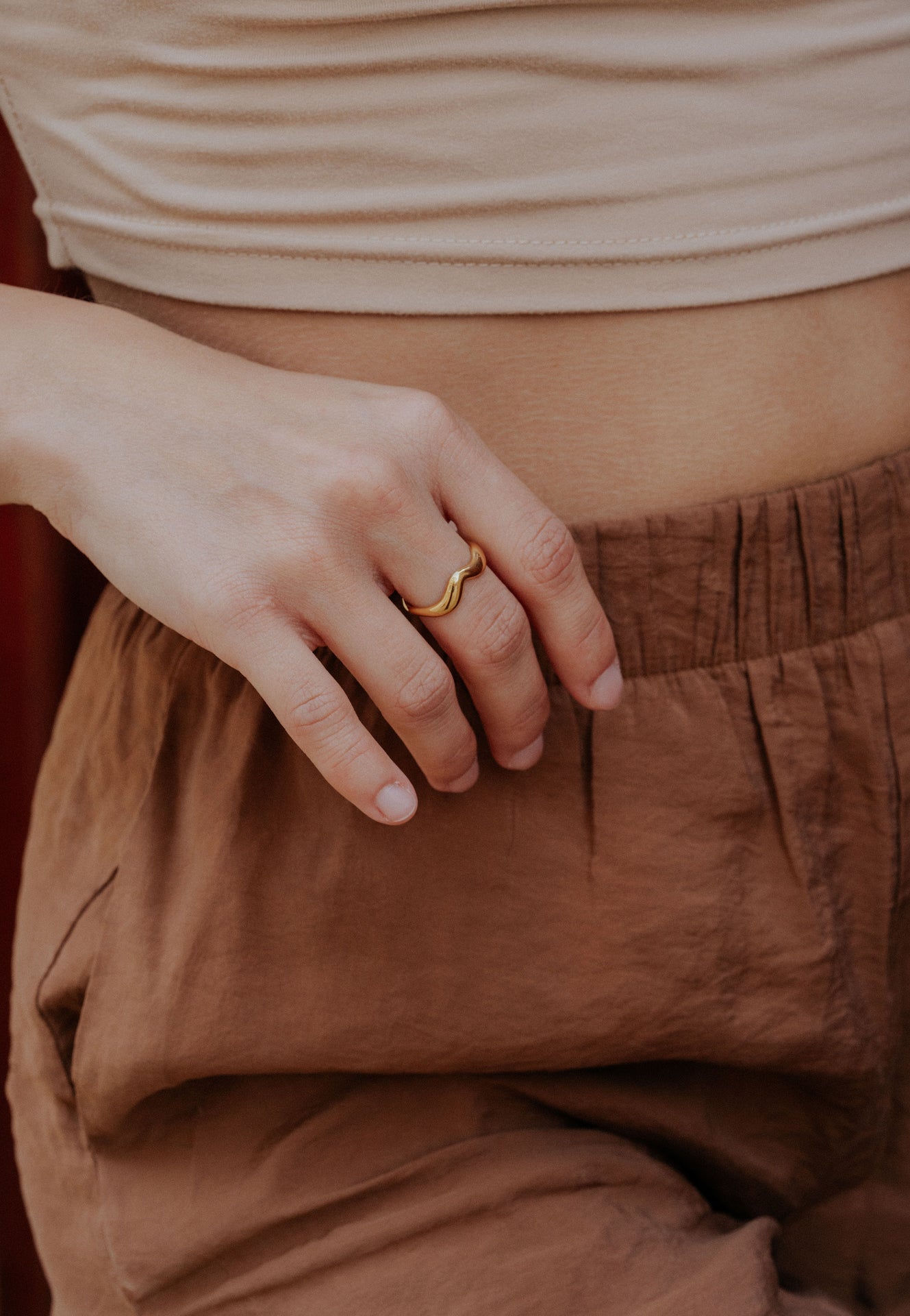 Close-up of a person wearing a gold ring on a blurred background
