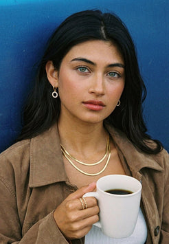 Woman holding a white mug against a blue background