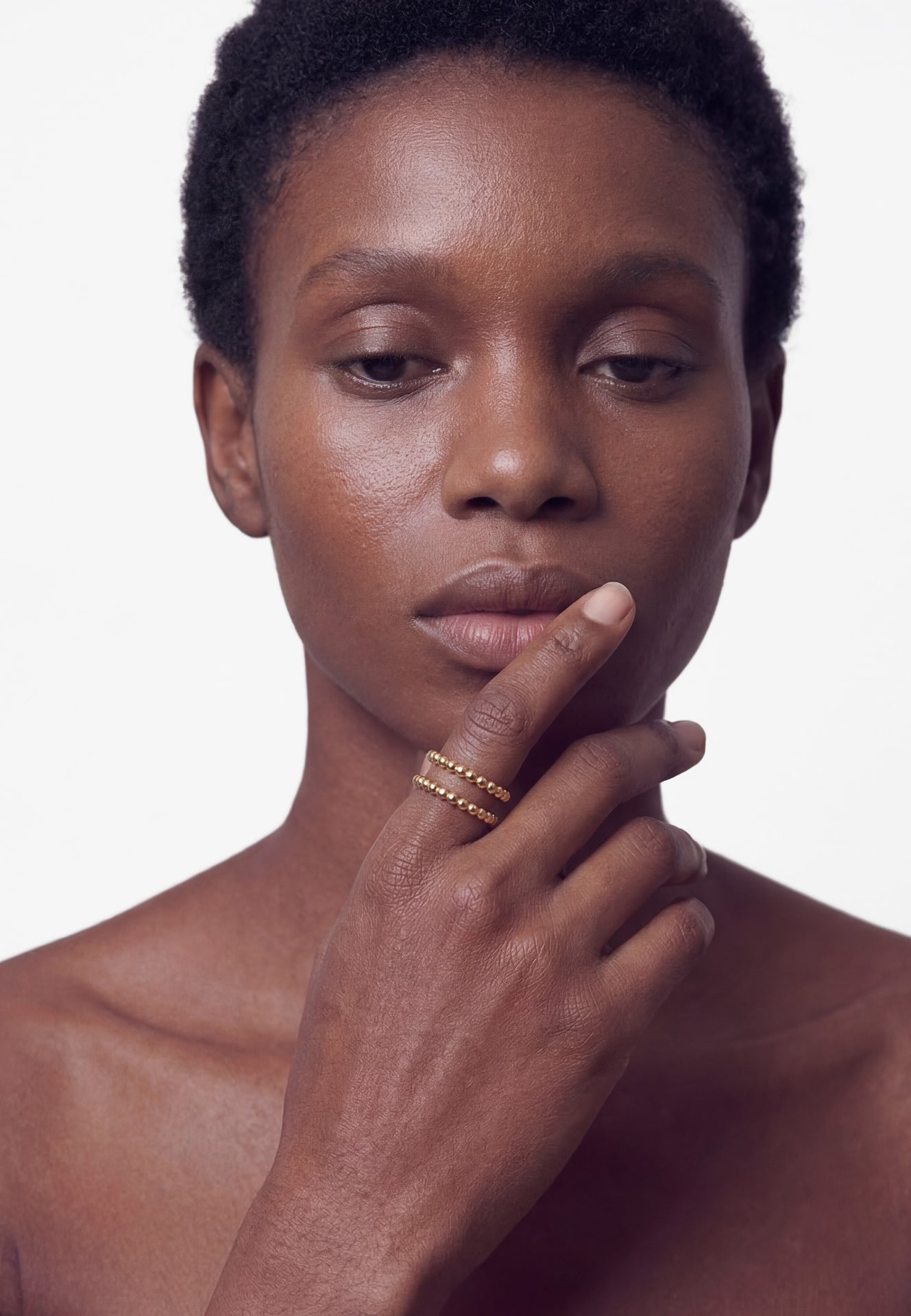 Woman with hand on chin against a white background