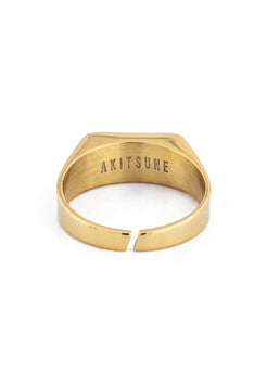 Gold ring with 'AKITSUNE' engraving on a white background
