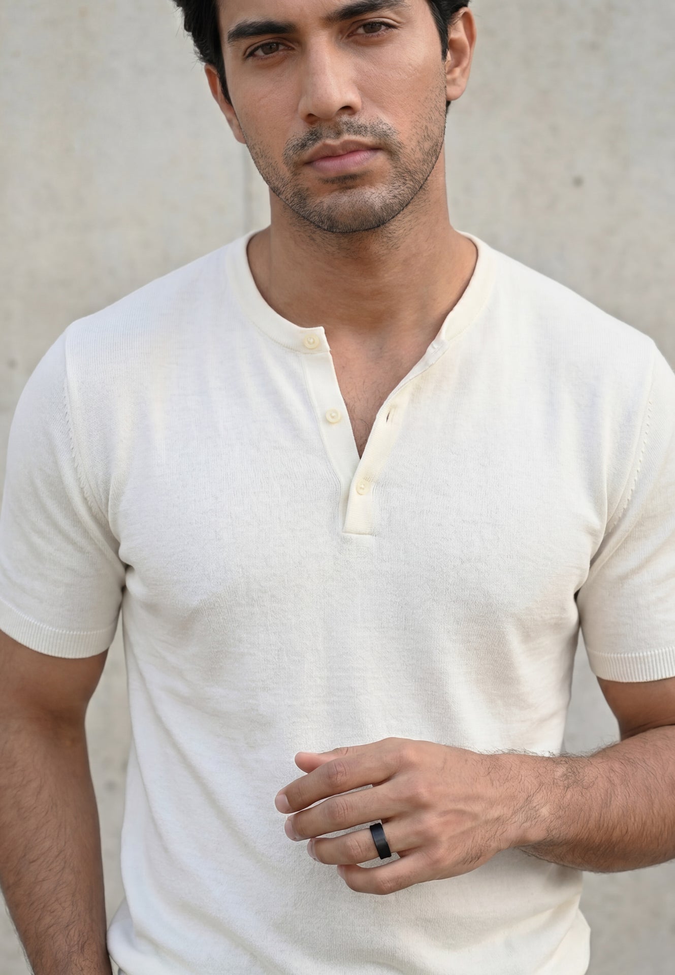 Man wearing a white shirt against a neutral background