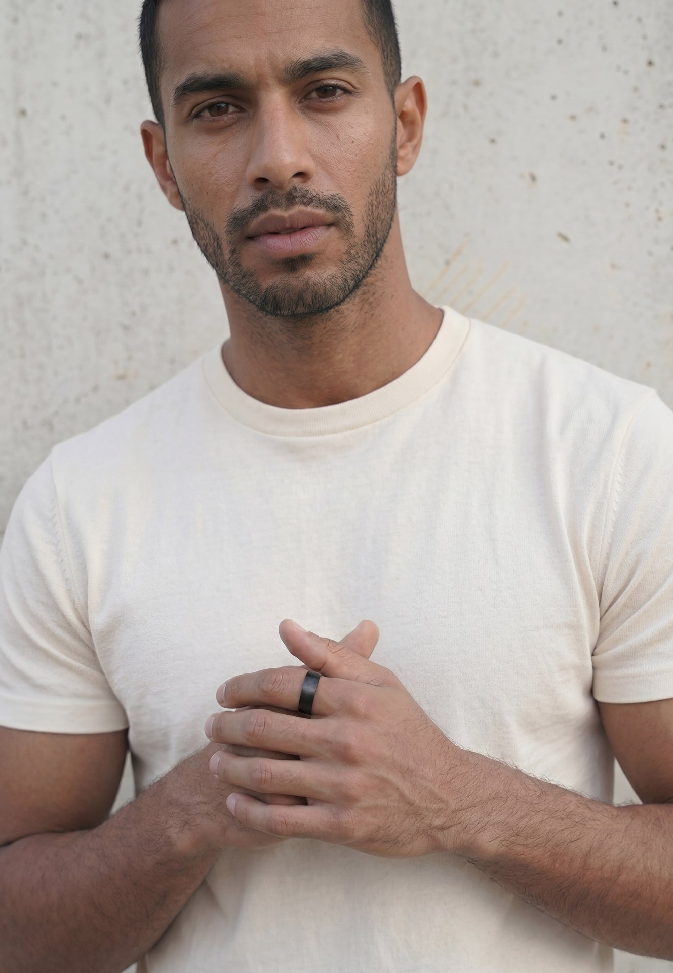 Man wearing a plain white t-shirt against a light background