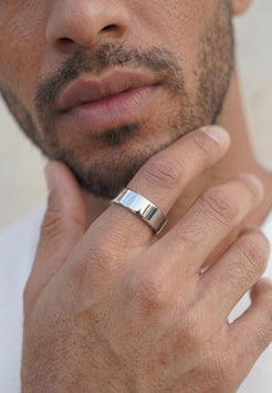 Close-up of male model wearing Akitsune Liber silver ring, featuring a polished minimalist band with a sleek contemporary design.