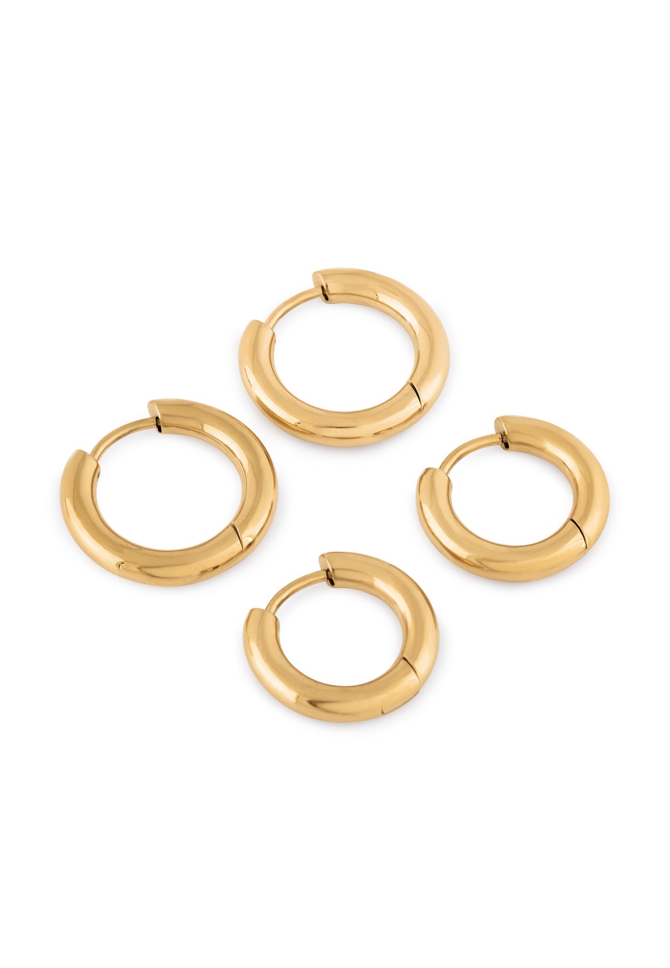 Set of gold hoop earrings on a white background