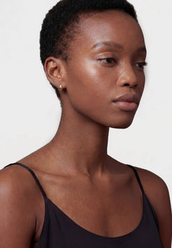 Woman wearing a black tank top against a white background