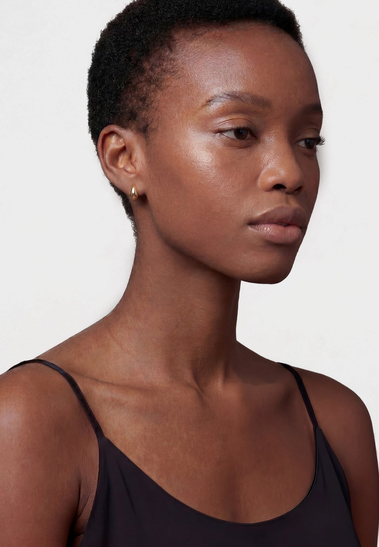 Woman wearing a black tank top against a white background