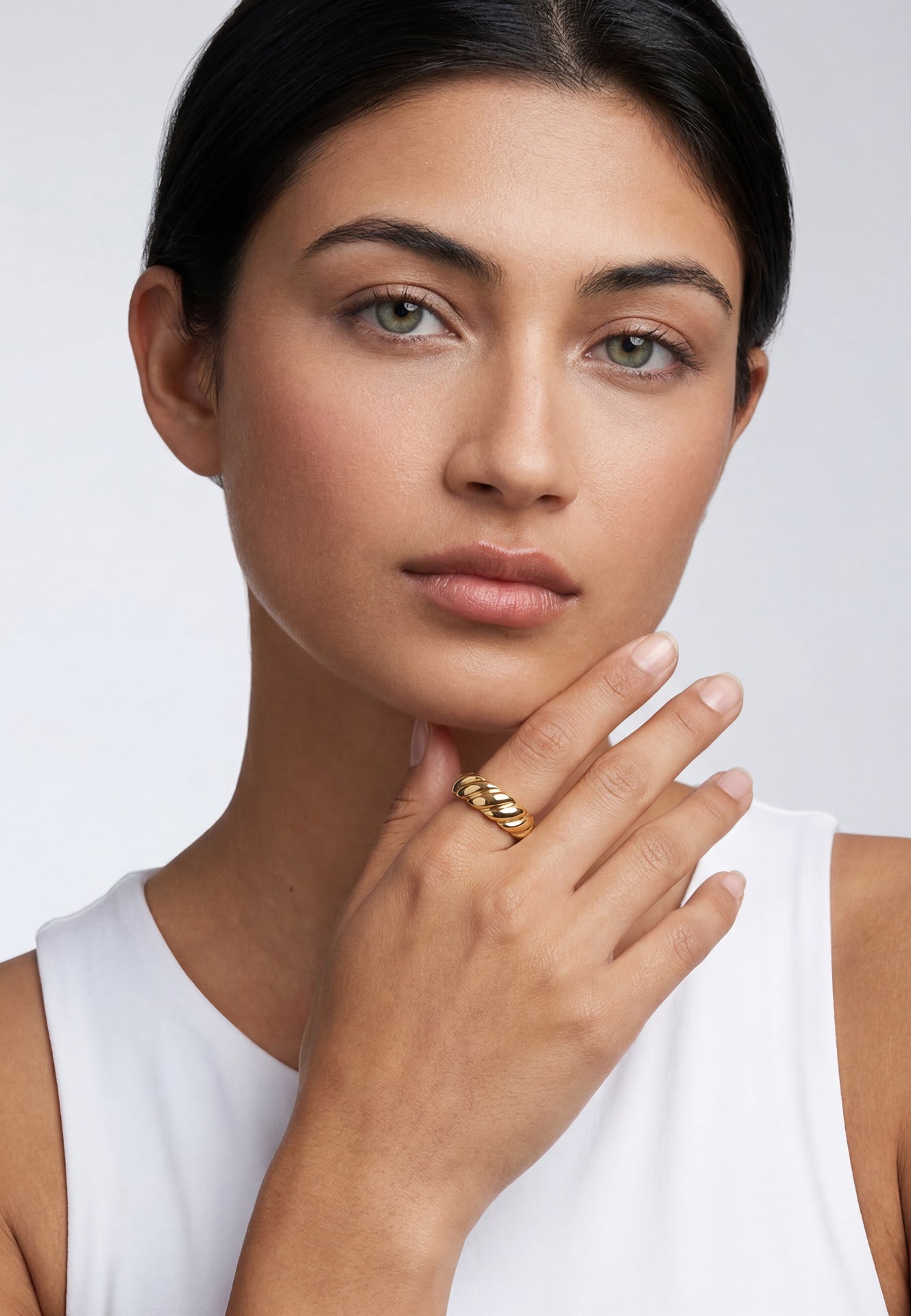 Woman wearing a gold ring on a white background