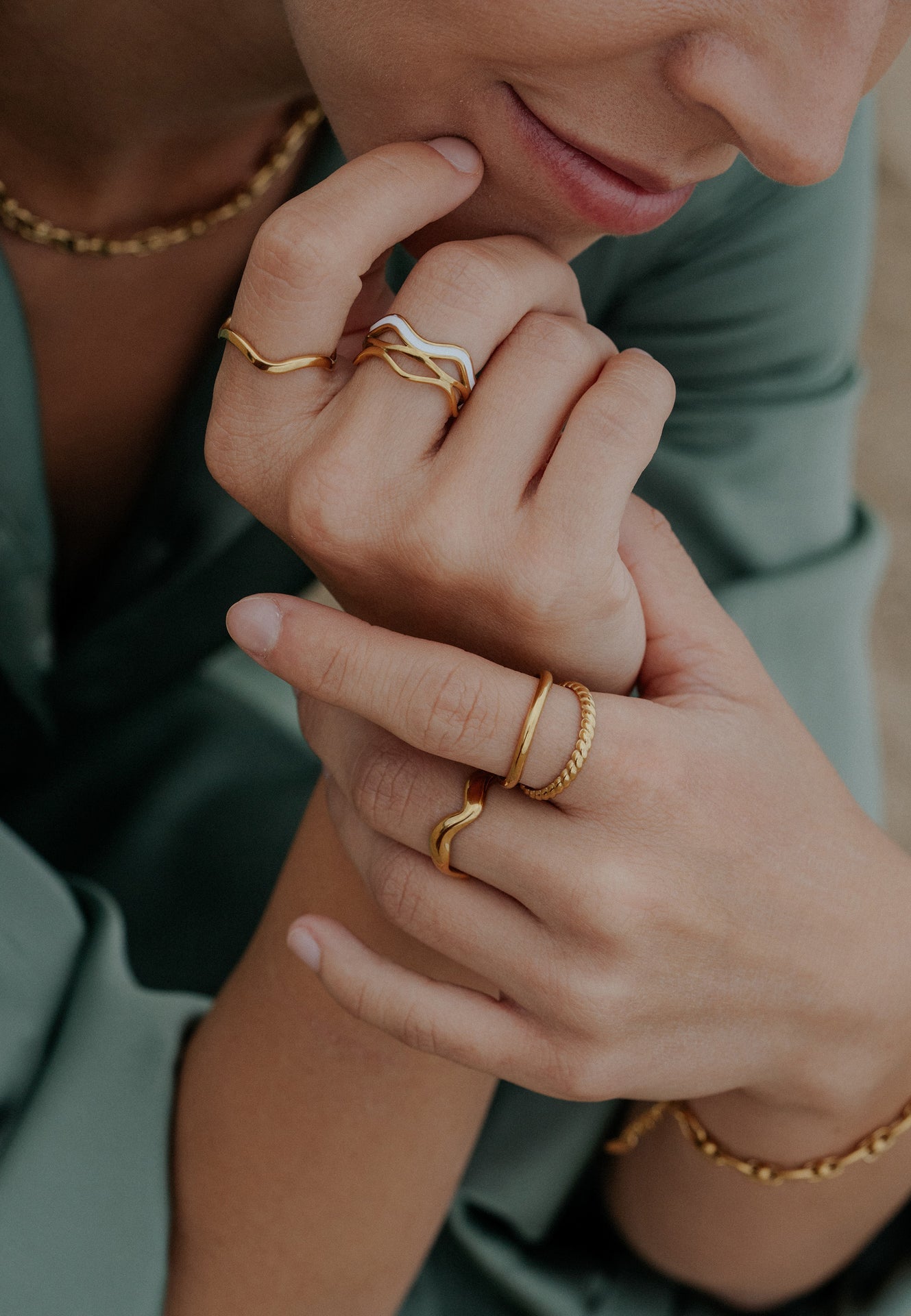 Close-up of hands wearing gold rings with a blurred background