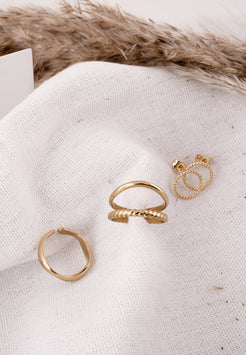 Three gold rings on a textured white surface with fur in the background
