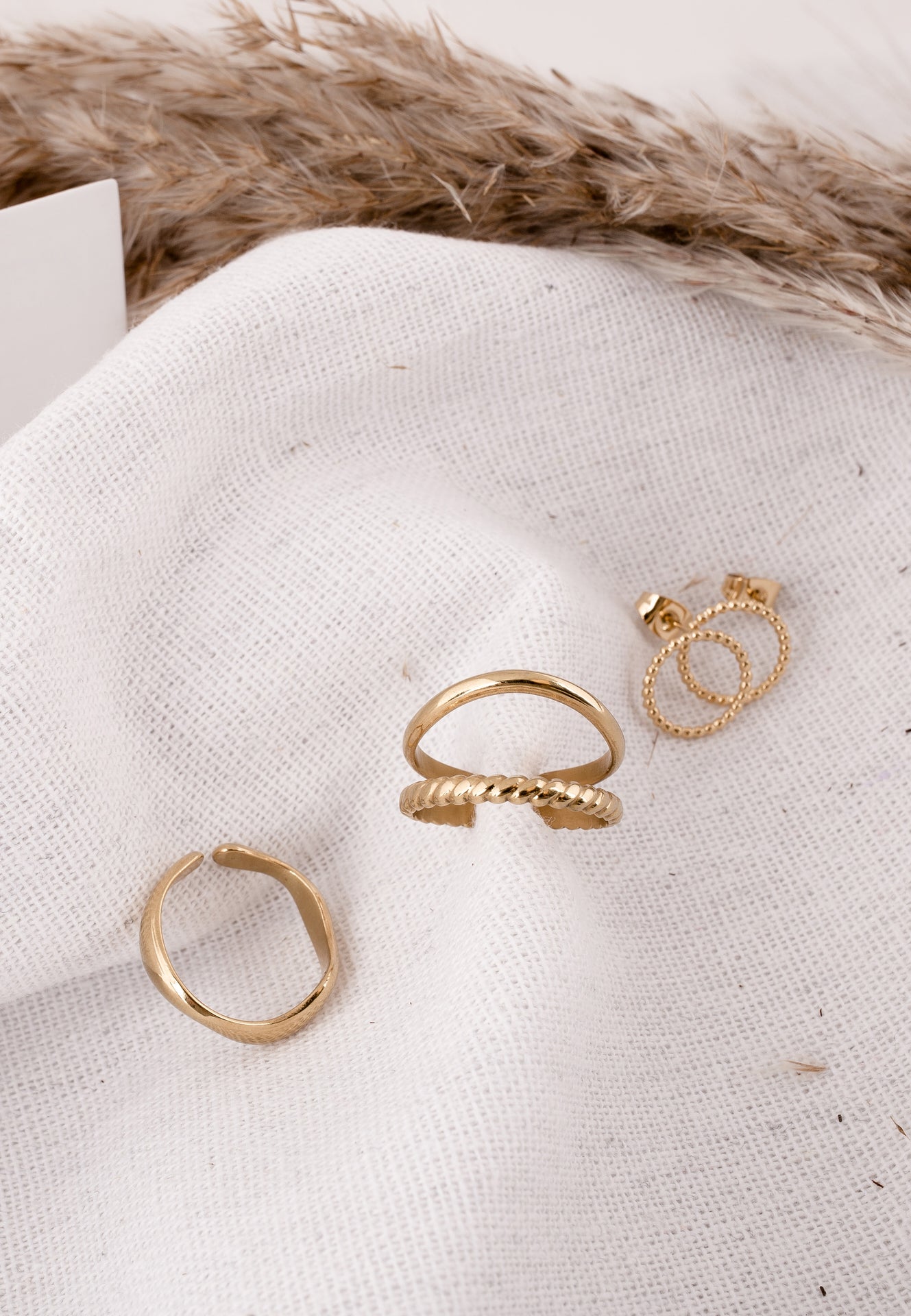 Three gold rings on a textured white surface with fur in the background