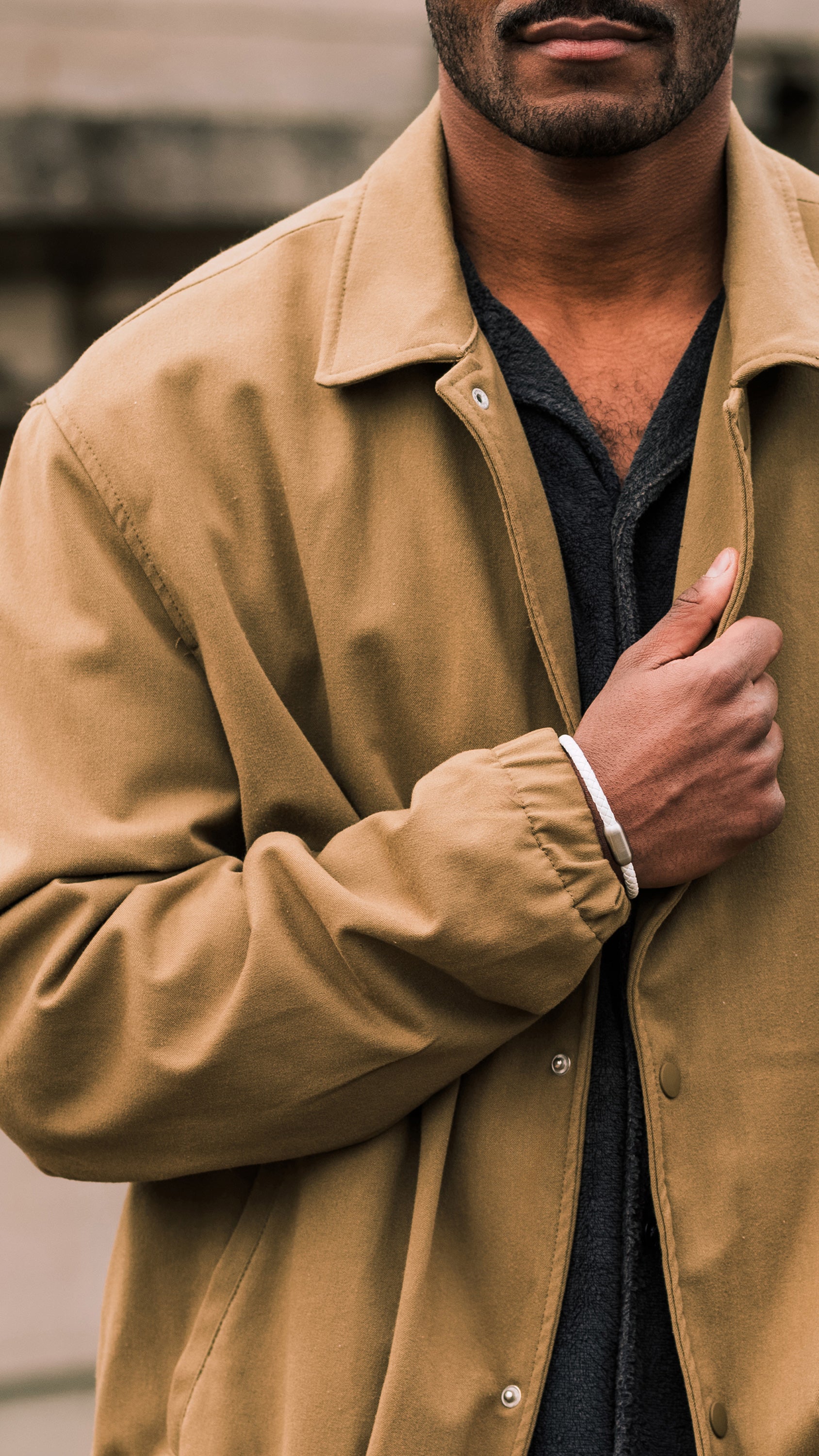Man wearing a beige jacket with a blurred background