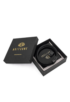 Black belt with gold logo in an open black box, featuring the brand 'Akitsune'.