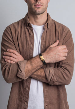 Model wearing Akitsune Simplicitas gold and black leather bracelet, featuring a minimalist handcrafted design with a premium black leather strap and elegant gold-tone accents.