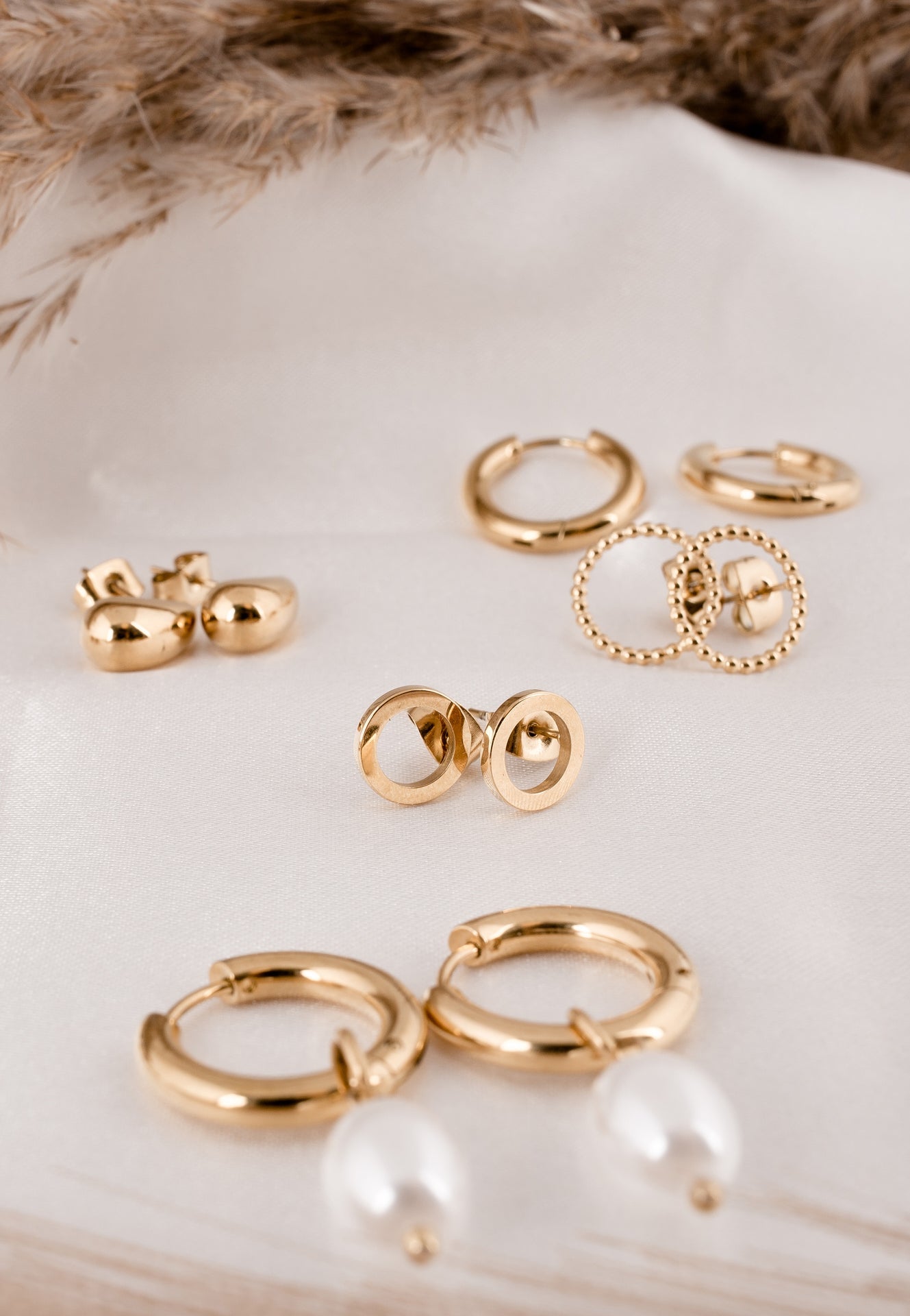 Set of gold earrings on a white shell