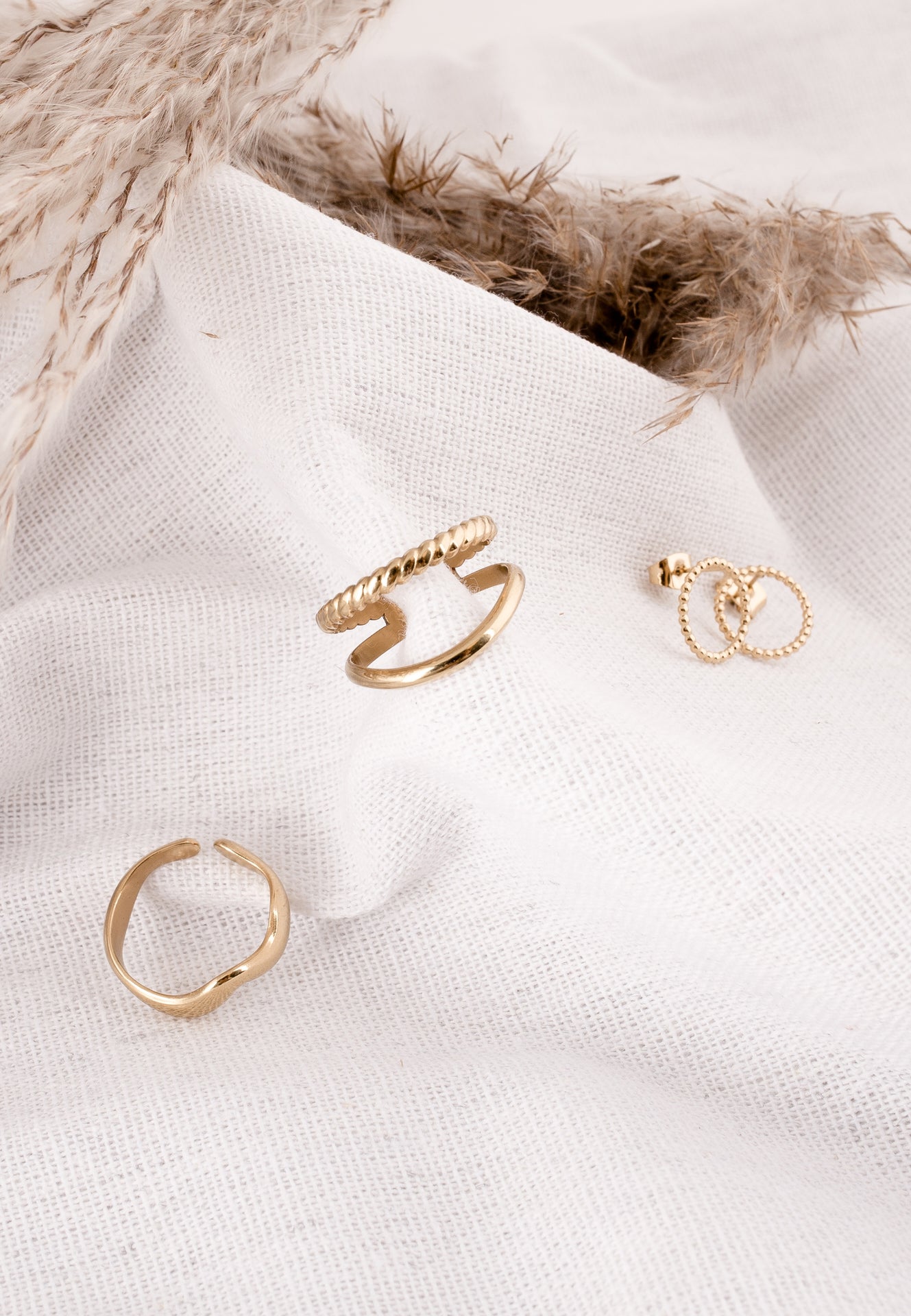Gold rings on a white fabric background