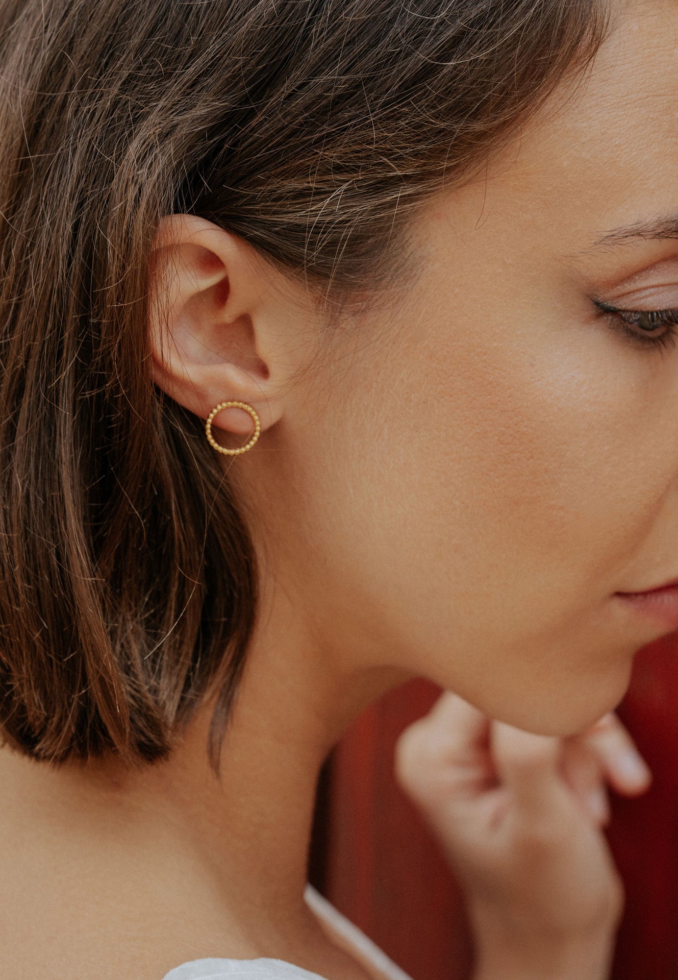 Close-up of a woman wearing a gold hoop earring.