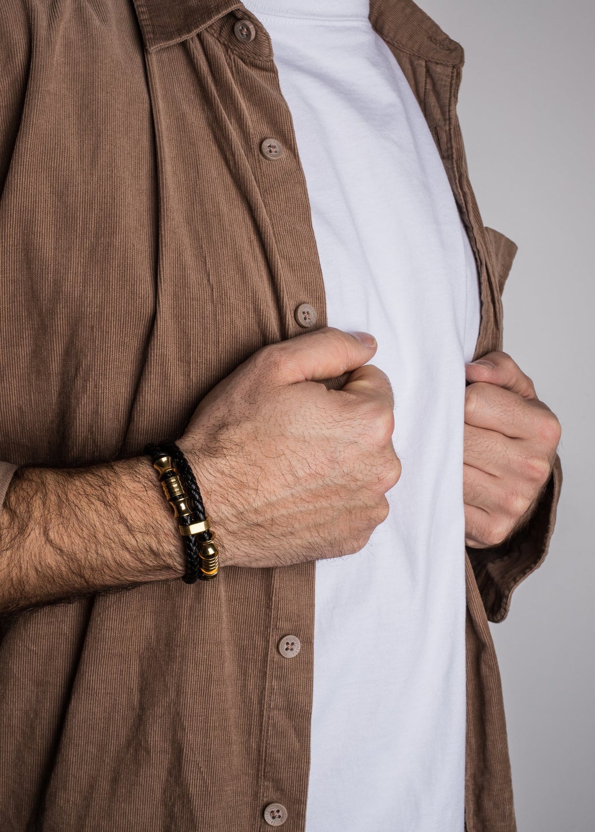 Person wearing a brown jacket over a white shirt with a neutral background